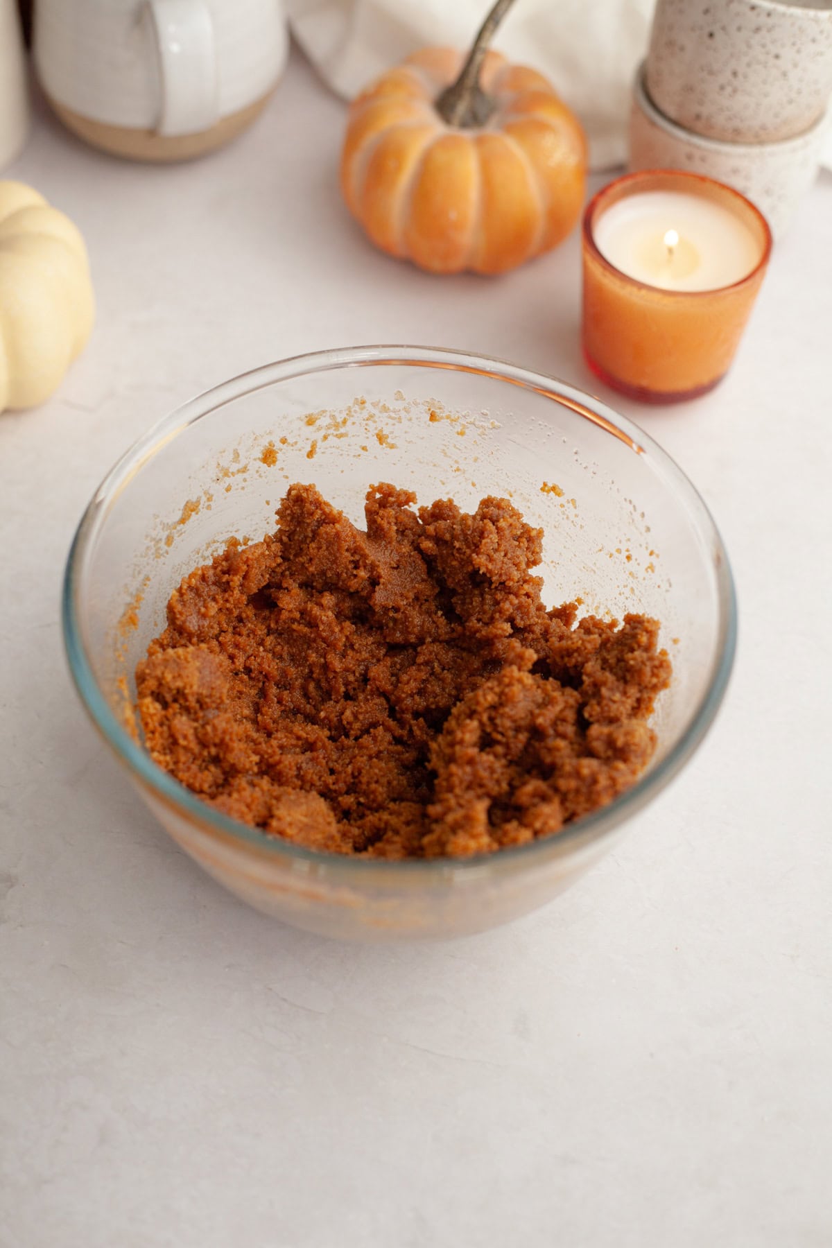 A small glass bowl with gingersnap cookie crumbs and melted butter.