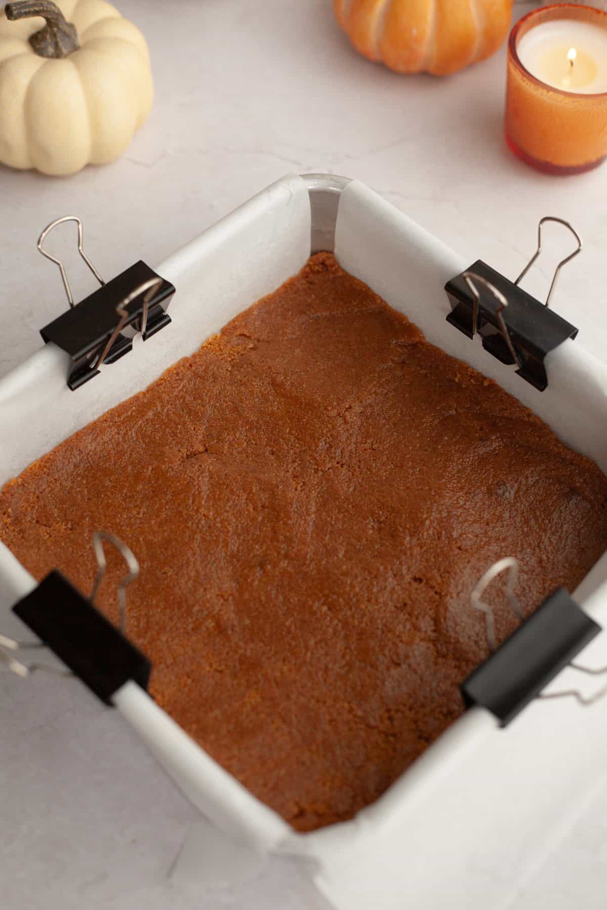 A square baking pan with a gingersnap cookie crust in it.