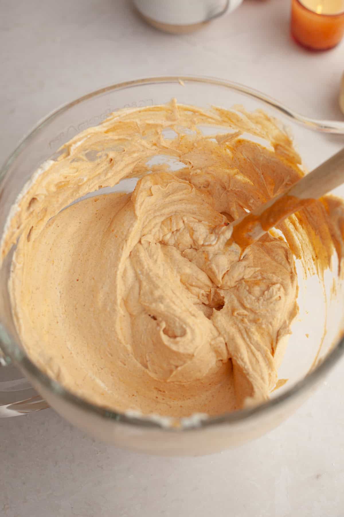 Pumpkin cheesecake filling in a glass bowl.