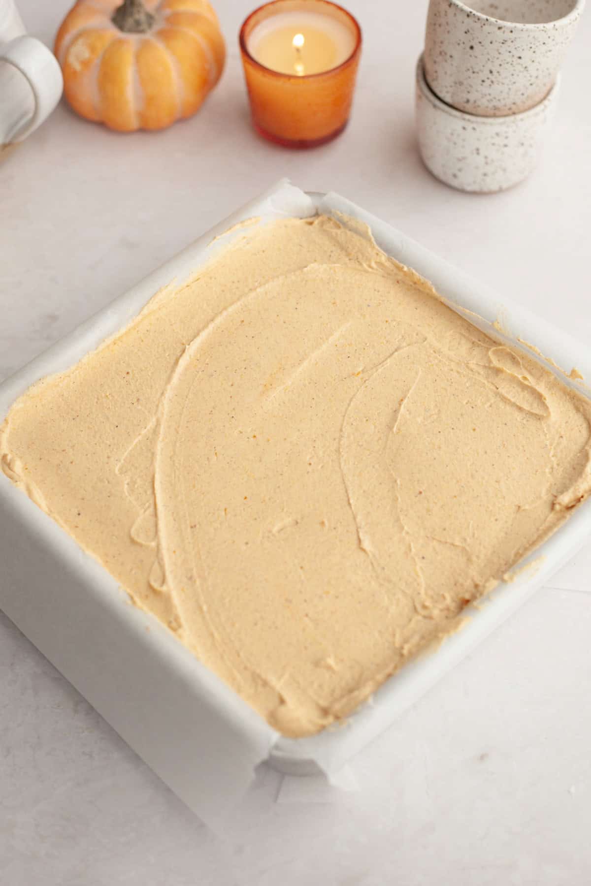 A square pan with pumpkin no bake cheesecake in it.