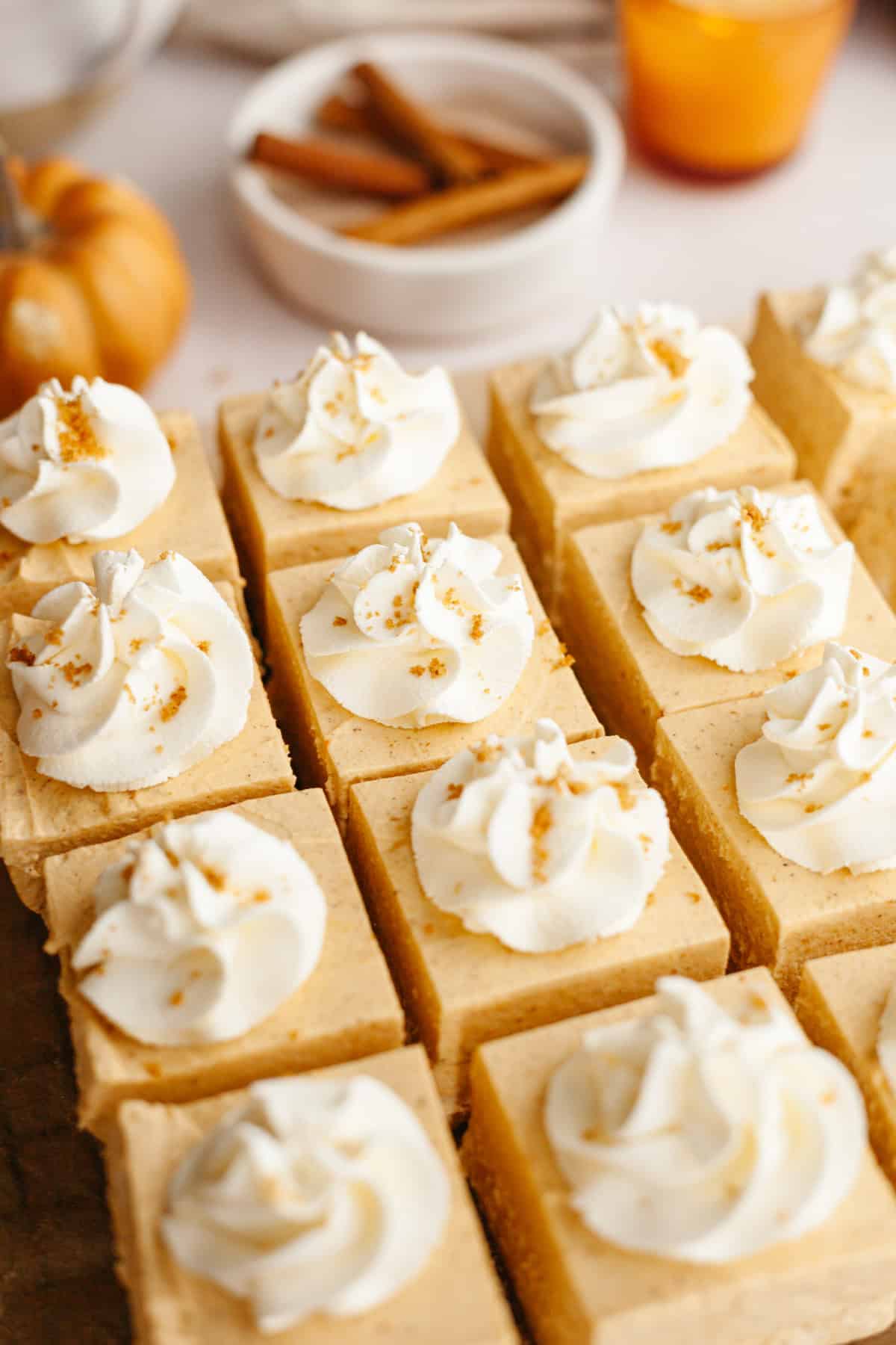 Square slices of pumpkin no bake cheese topped with whipped cream.