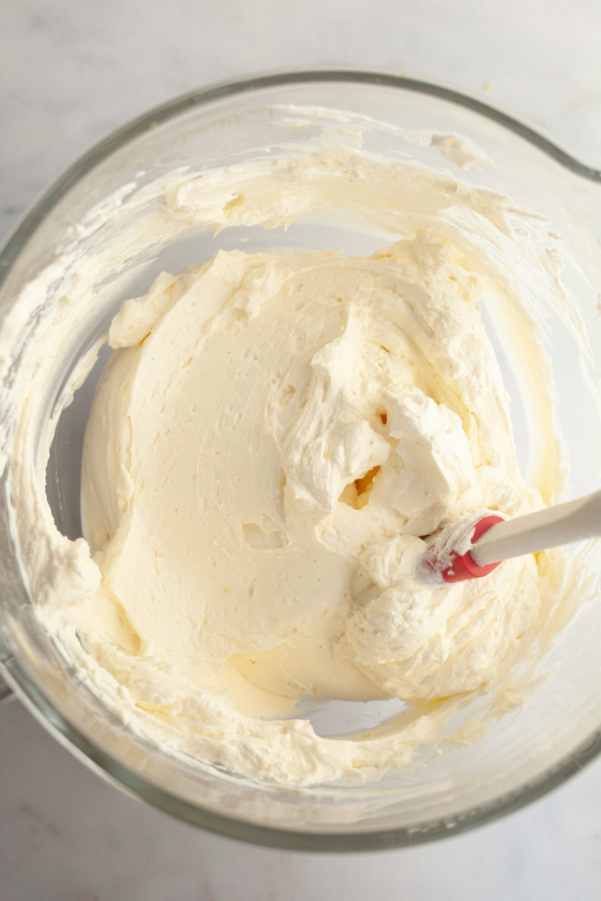 Vanilla cheesecake filling in a glass bowl.