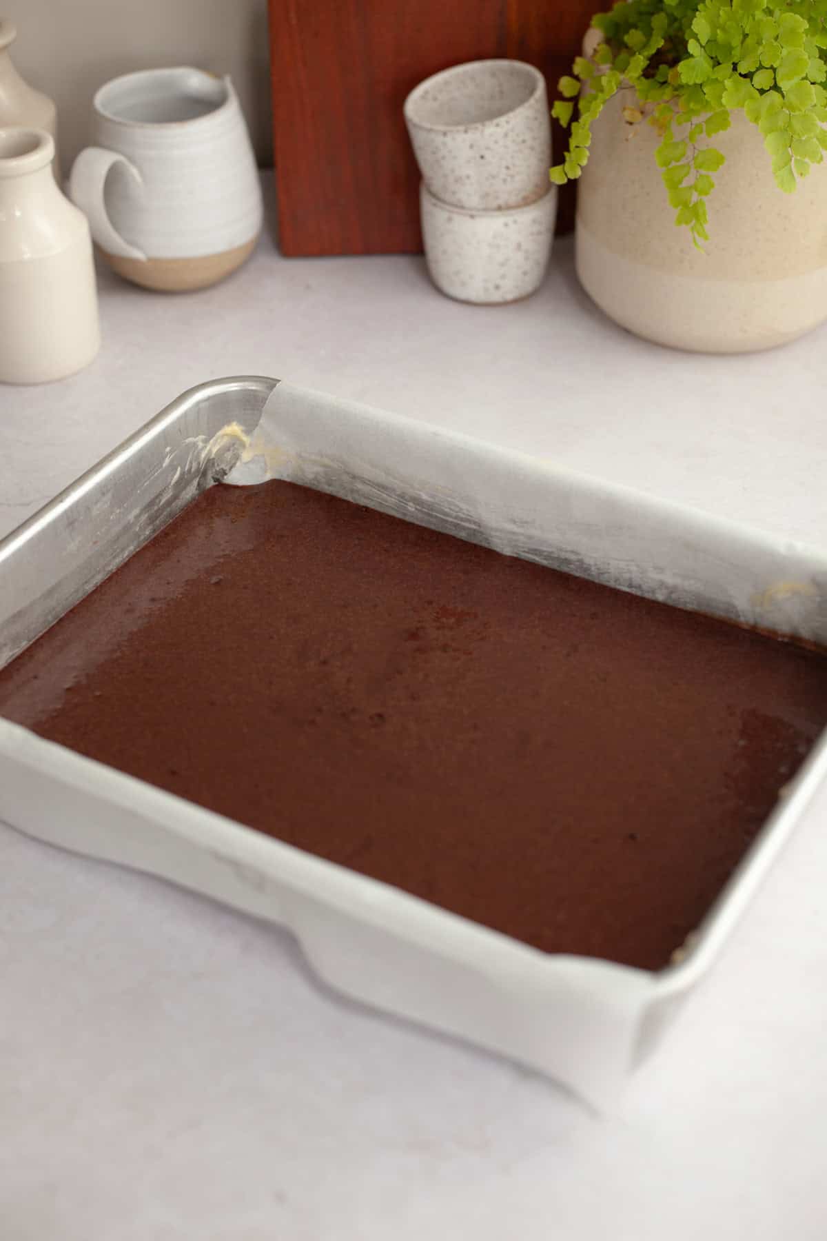 Unbaked chocolate cake in a rectangular pan.