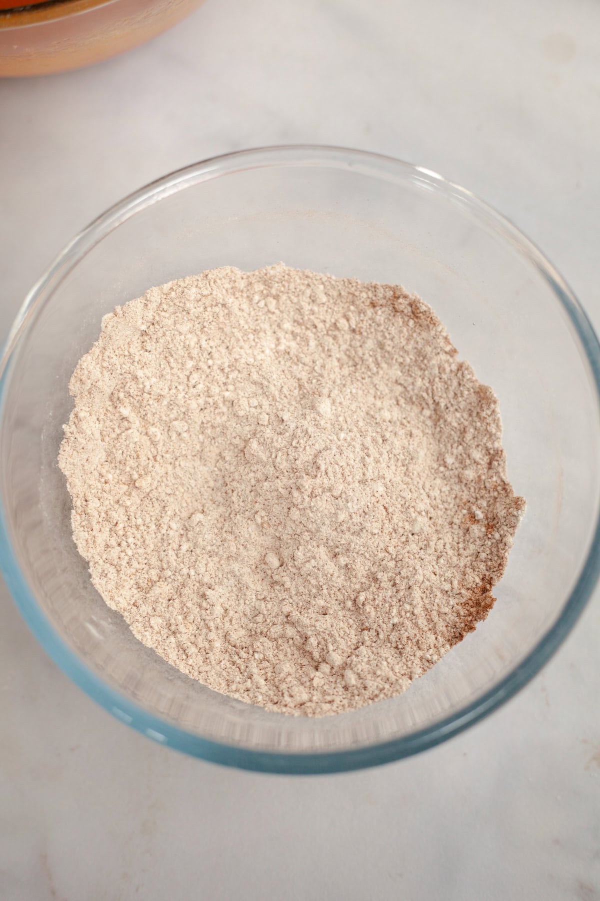 A glass bowl with flour and spices.