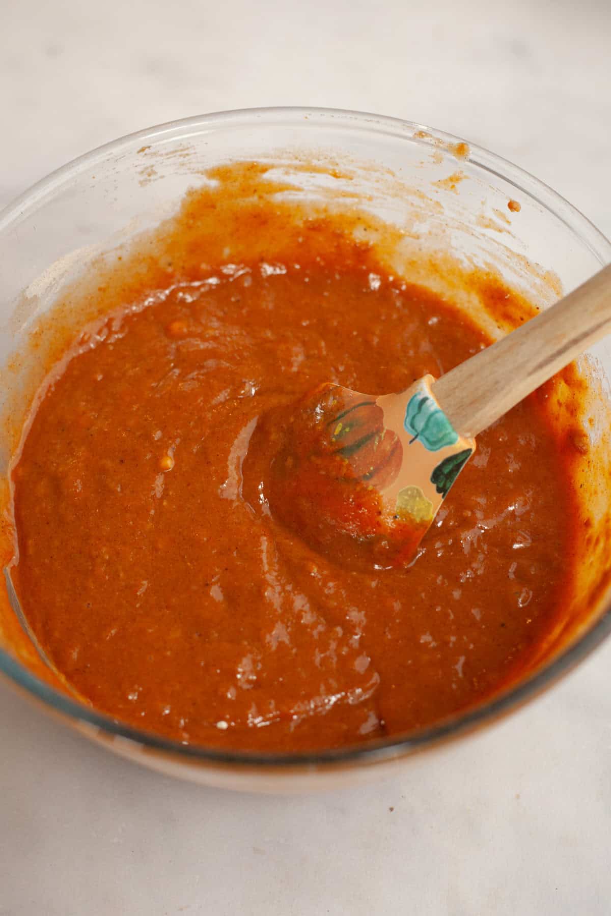 Pumpkin cupcake batter in a glass bowl.