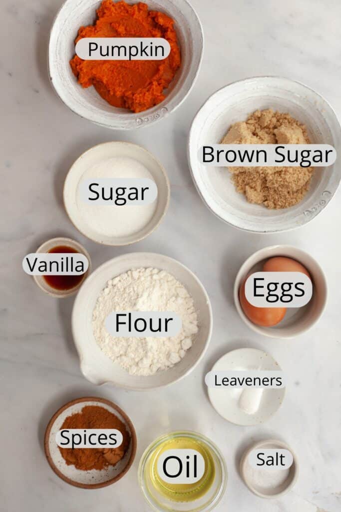 All the ingredients needed to make pumpkin spice cupcakes, weighed out into small bowls.