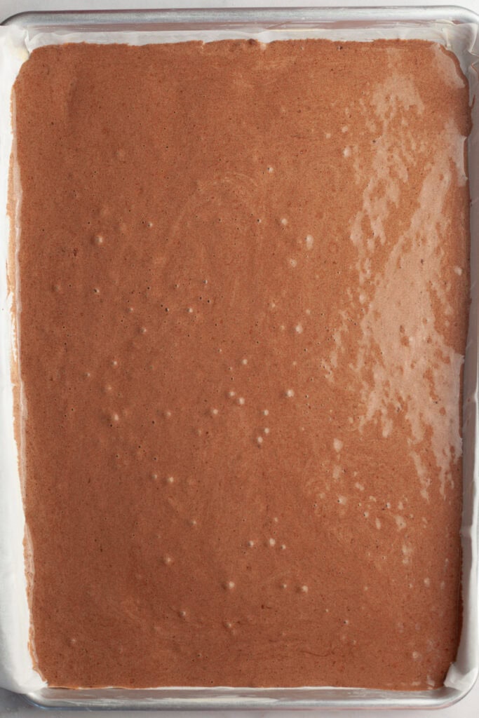 A half sheet pan with unbaked chocolate cake batter.