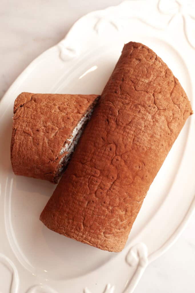A white serving platter with an unfrosted yule log.