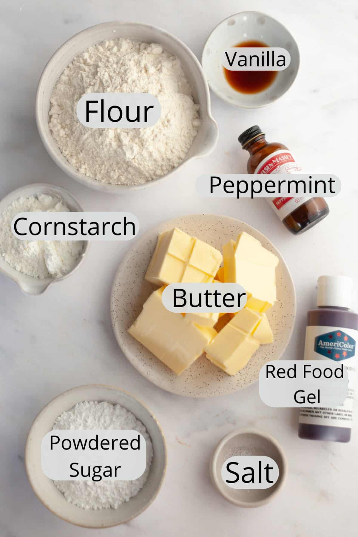 All the ingredients needed to make candy cane shortbread cookies, weighed out into small bowls.