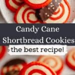 Red and white pinwheel candy cane shortbread cookies on a small plate, some of the cookies have been half dipped in chocolate. A hand is holding one cookie.