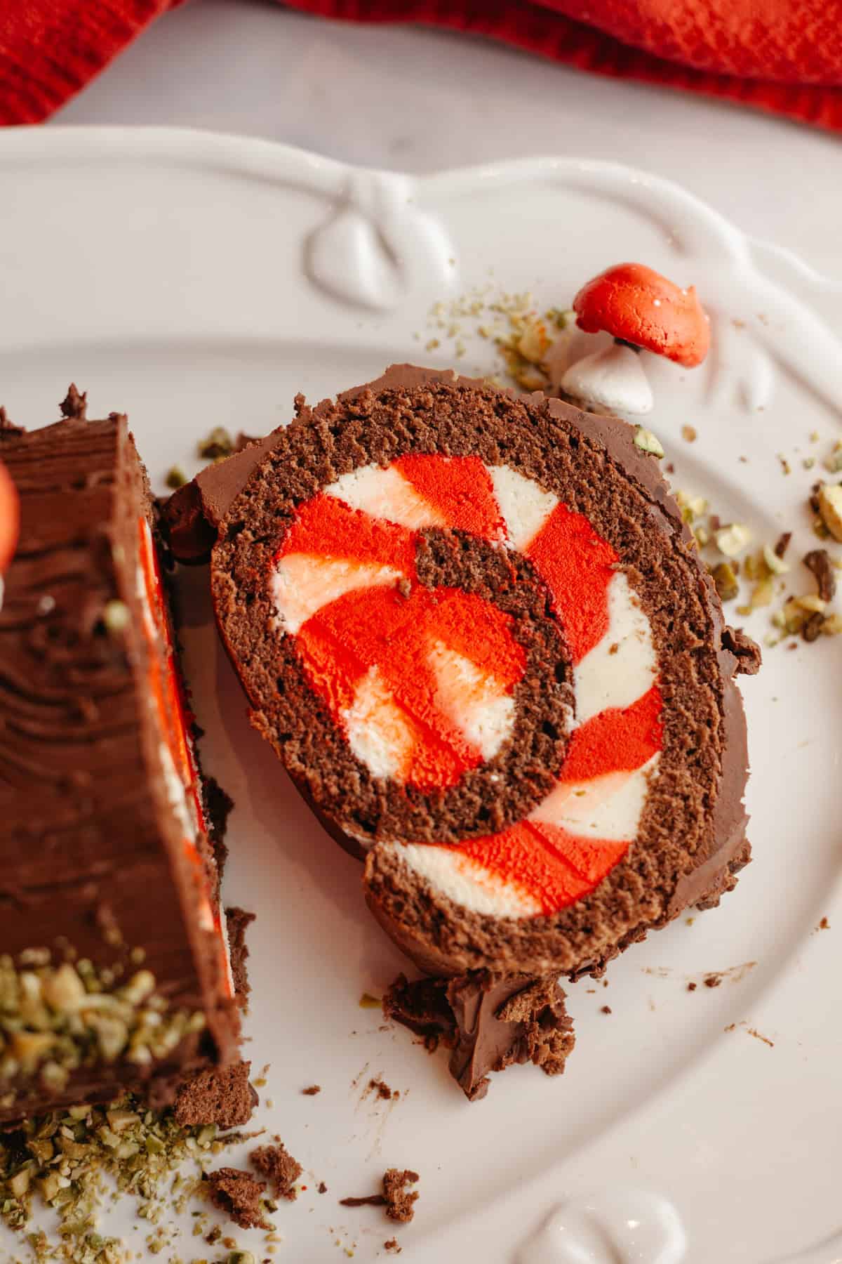 A slice of peppermint bark yule log on a white platter.