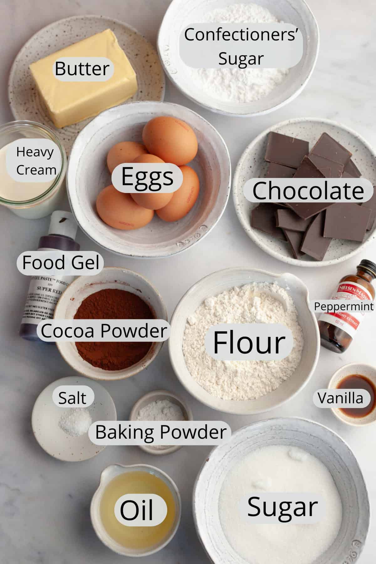 All the ingredients needed to make a peppermint bark yule log, weighed out into small bowls.