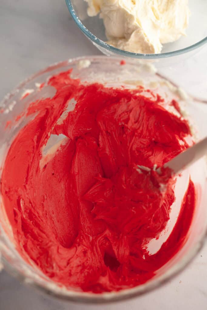 Red frosting in a glass bowl.