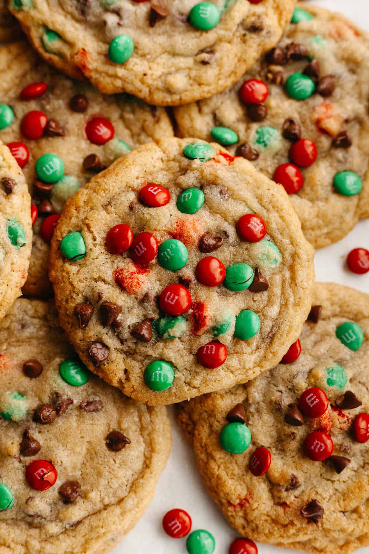 A close up of chocolate chip cookies with red and green M&Ms.