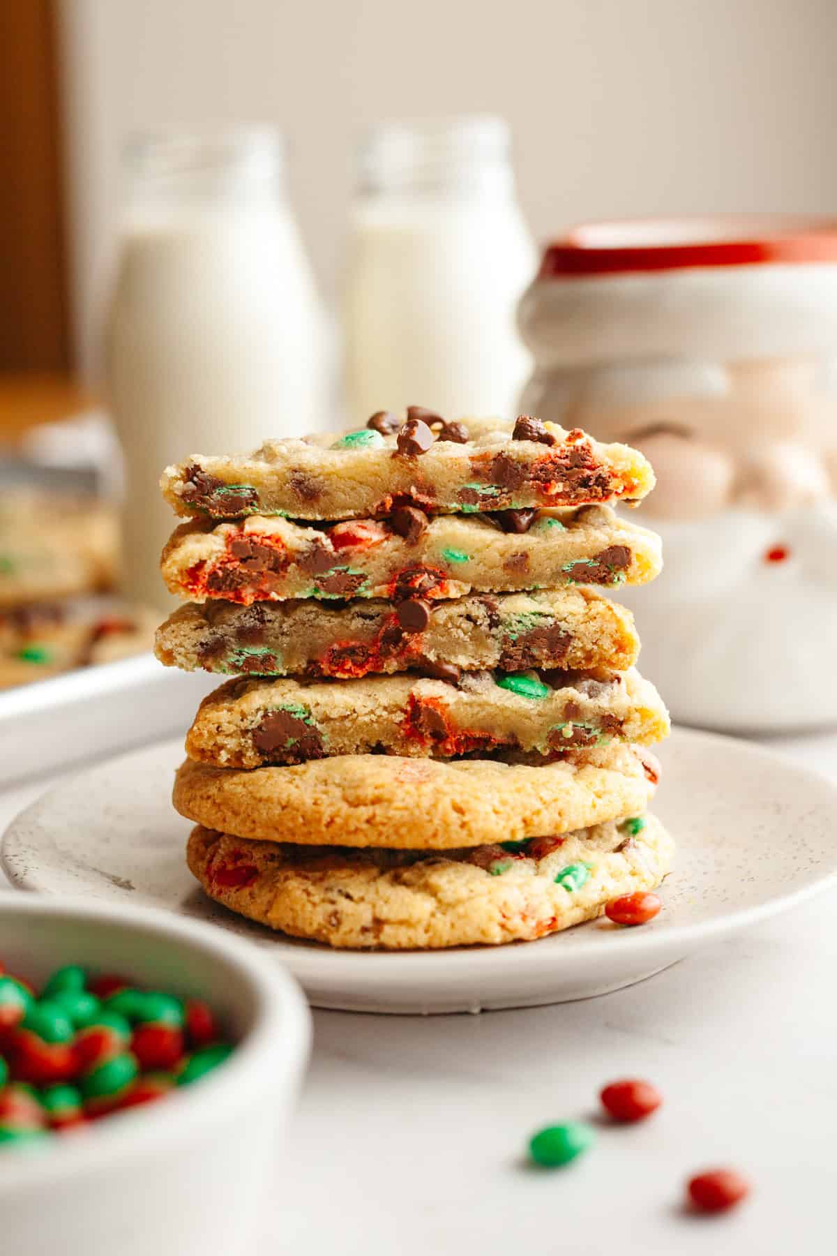 A stack of M&M chocolate chip cookies on a small plate.