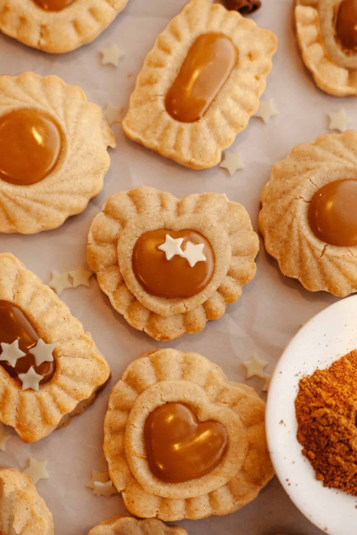 Cinnamon cookies with Biscoff middles on parchment paper.