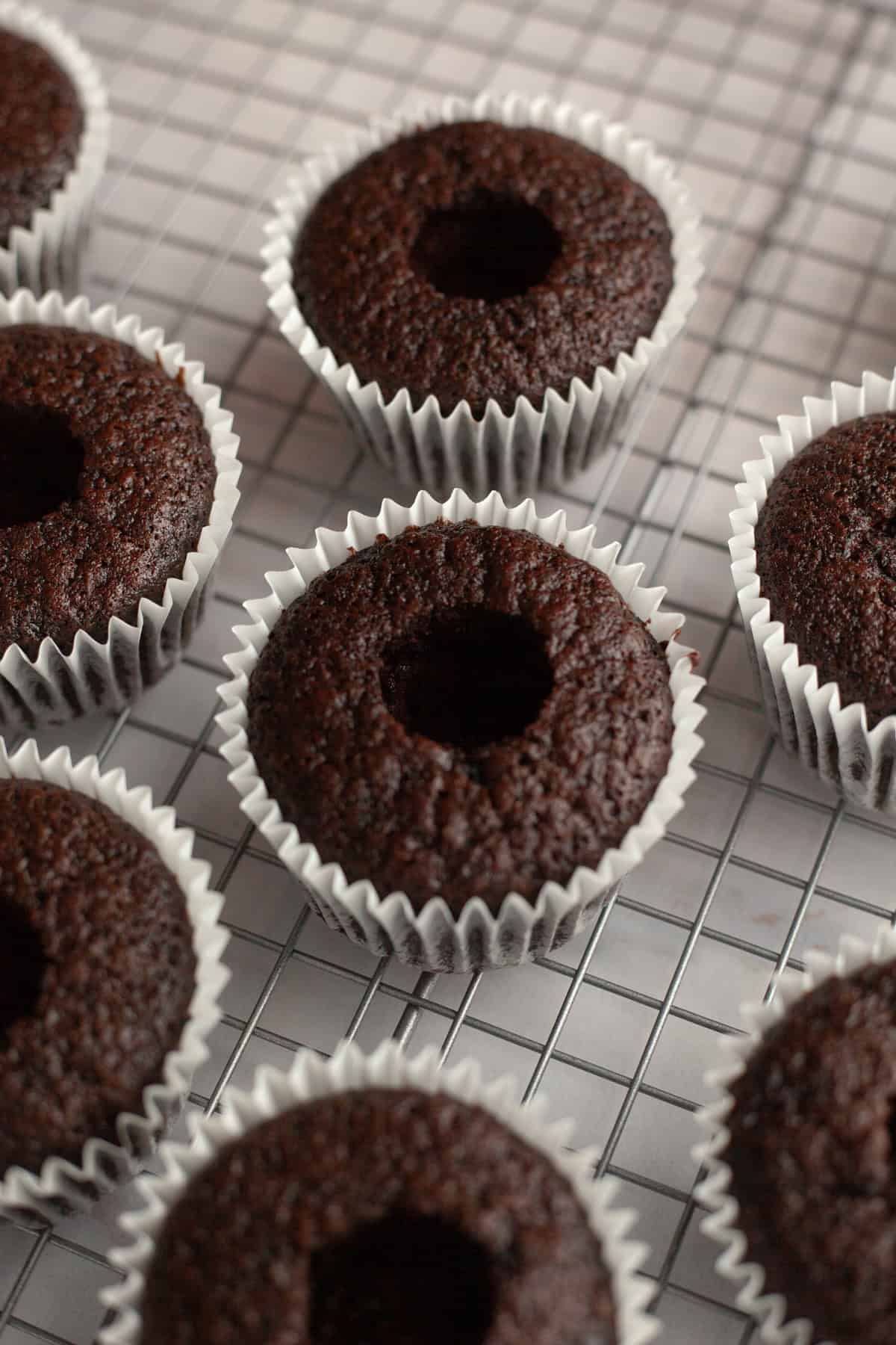 Chocolate cupcakes with their centers cored out.