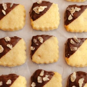 Three lines of ginger shortbread cookies, half dipped in chocolate and crystallized ginger.