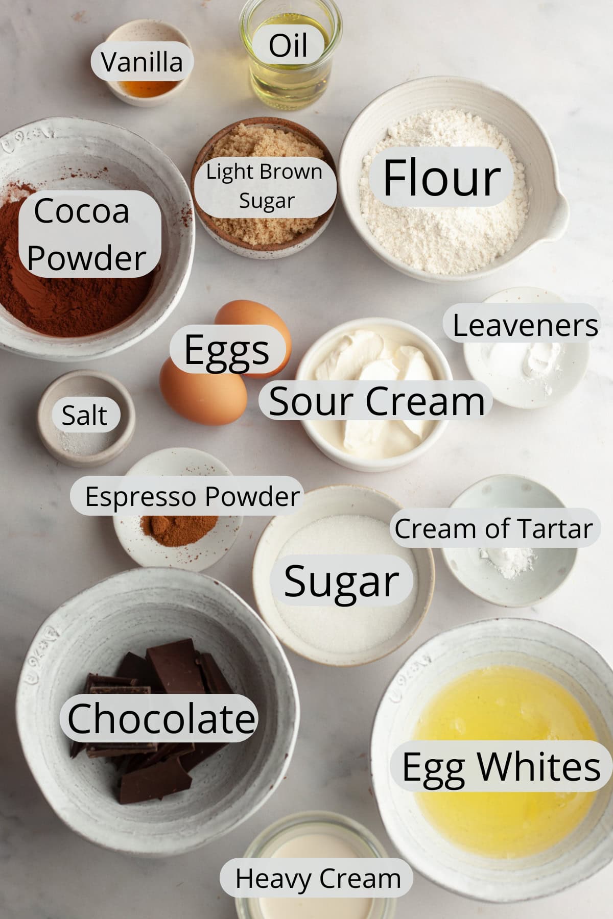 All the ingredients needed to make hot cocoa cupcakes, weighed out into small bowls.