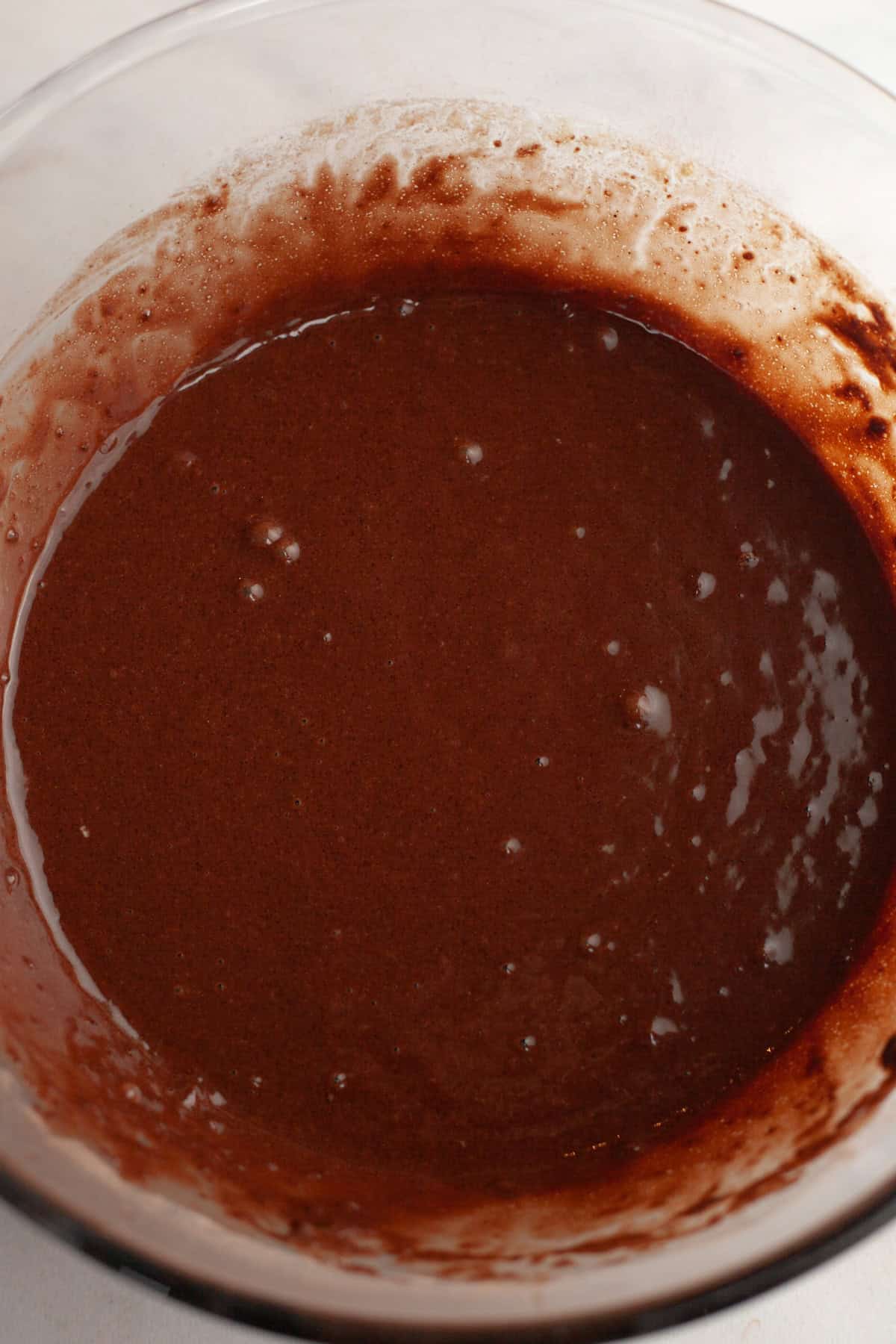 Chocolate cupcake batter in a glass bowl.