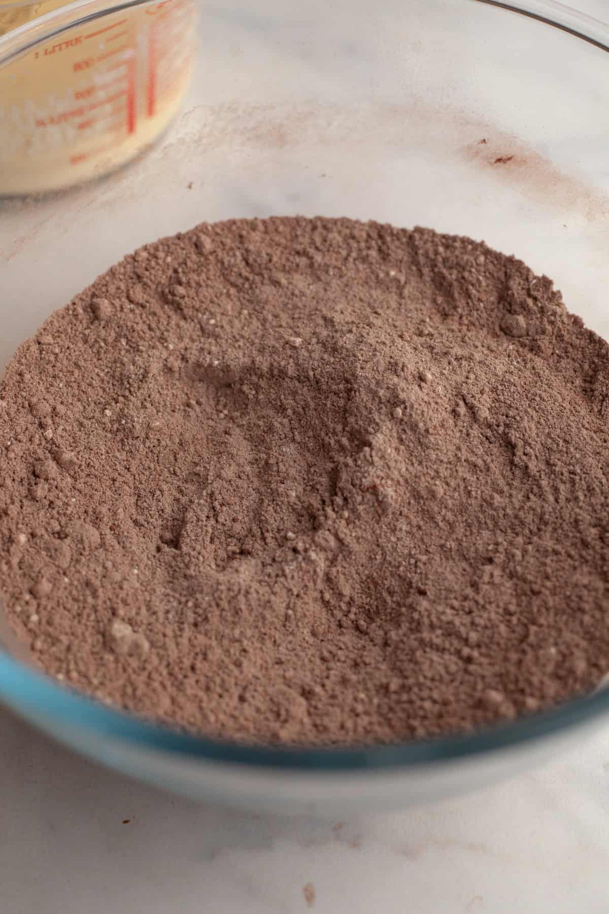 Cocoa powder and flour in a glass bowl.