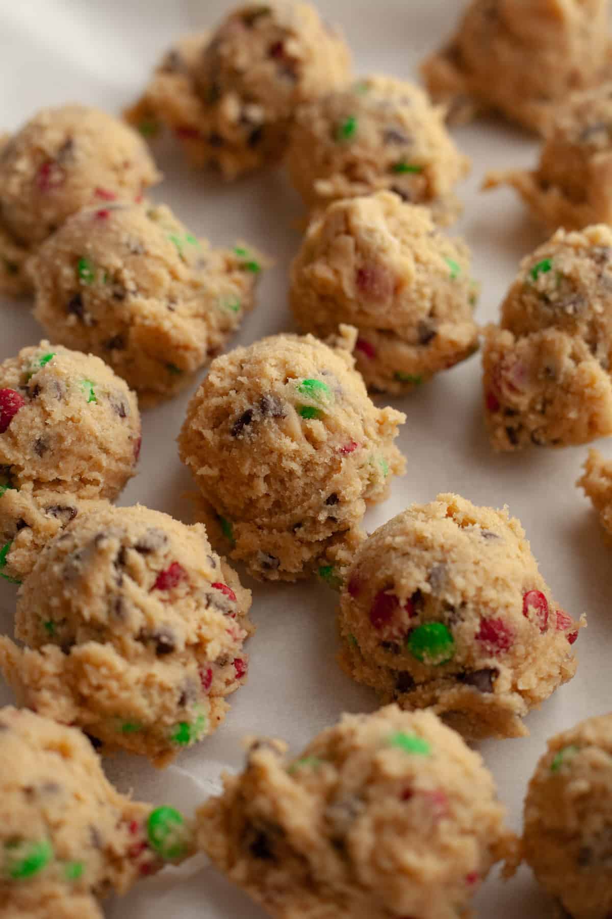 M&M chocolate chip cookie dough balls on parchment paper.