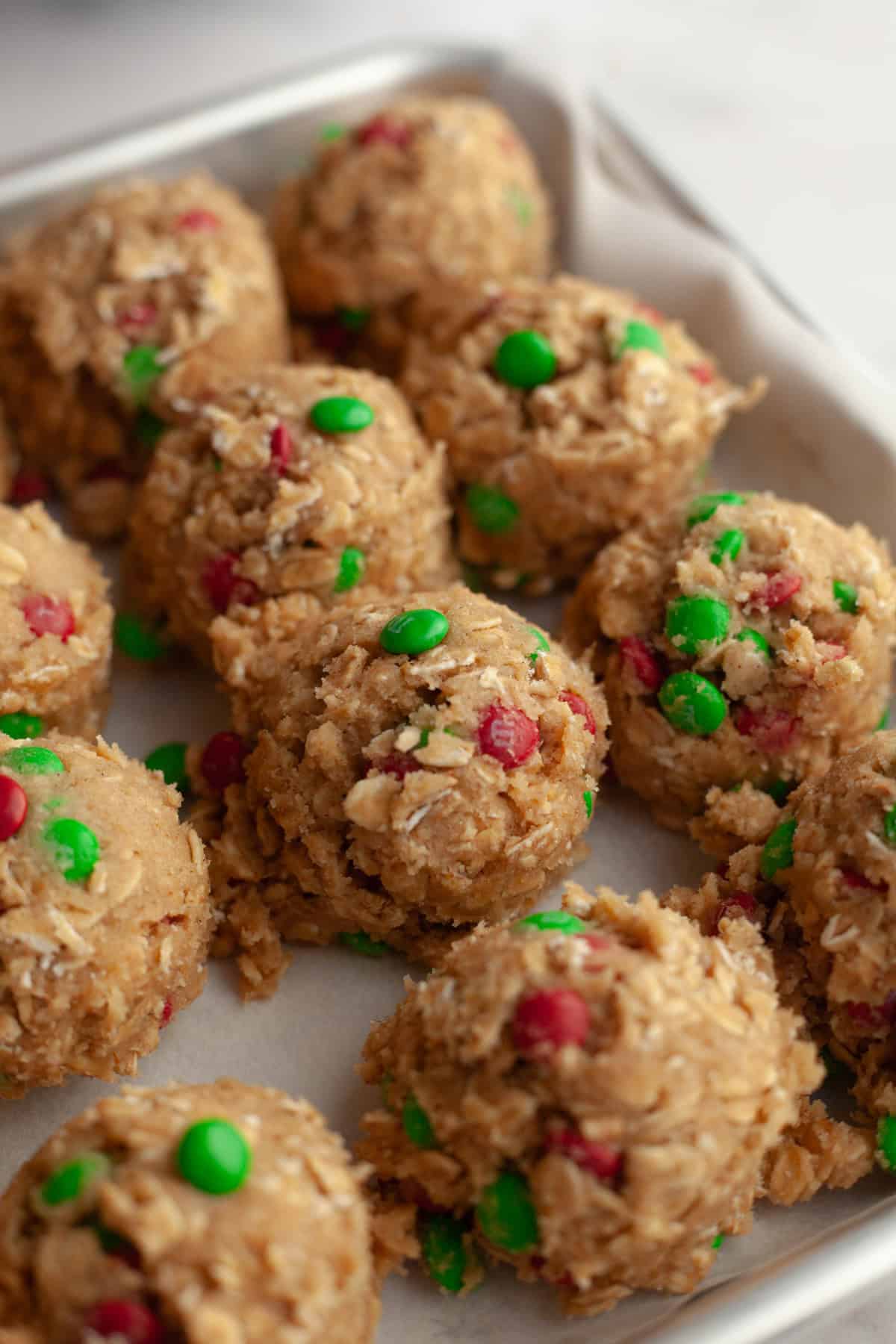 Christmas oatmeal cookie dough balls on parchment paper.