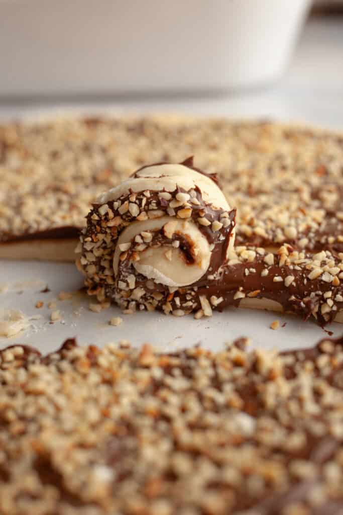 Rolling up Nutella cinnamon rolls into buns.
