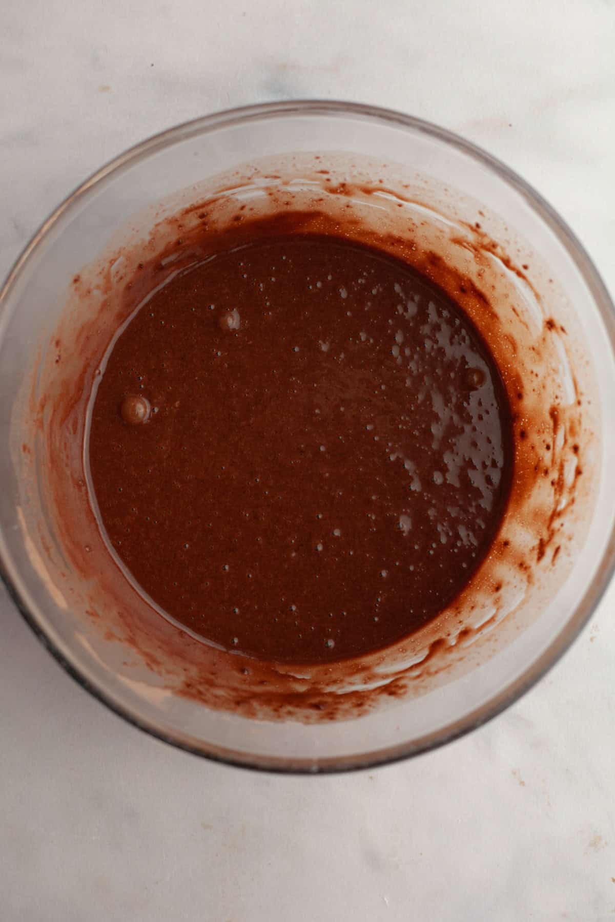 Chocolate cupcake batter in a glass bowl.