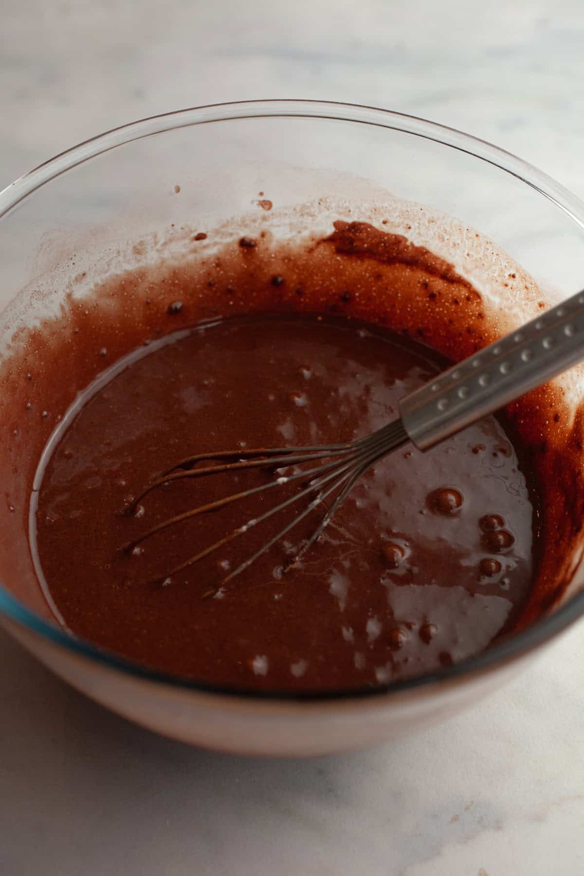 Chocolate cupcake batter in a bowl with a whisk.