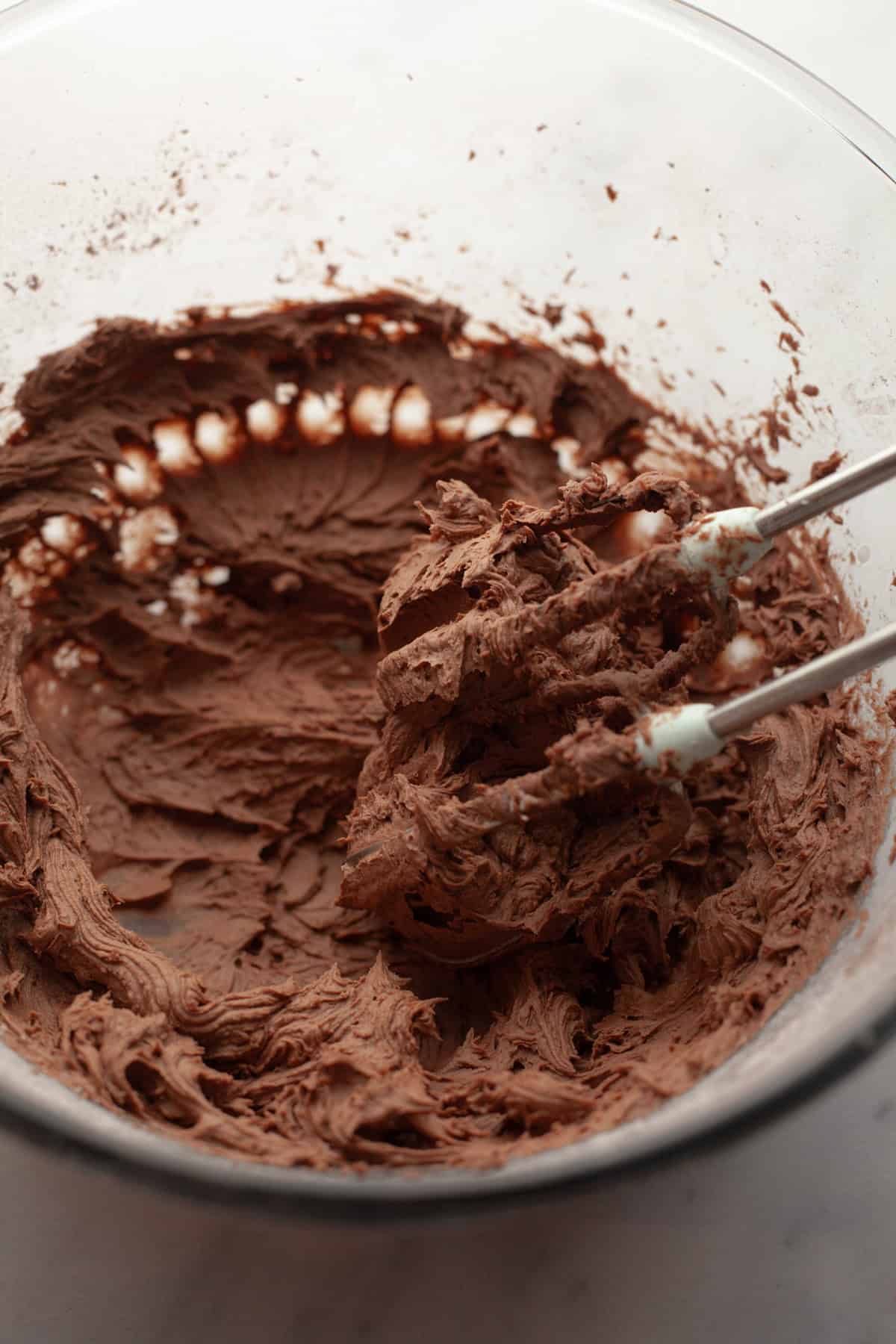 Chocolate frosting in a glass bowl.