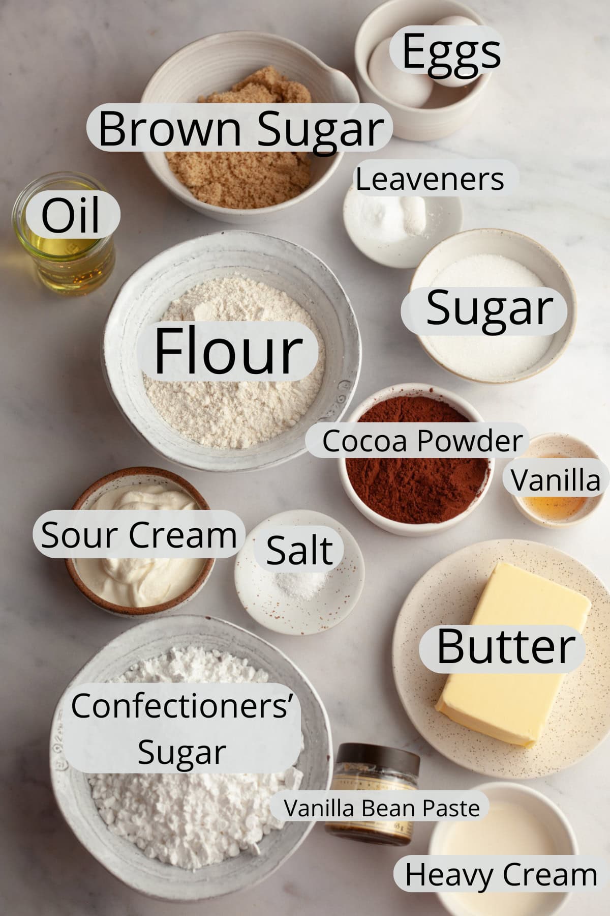 All the ingredients needed to make chocolate cupcakes with vanilla buttercream, weighed out into small bowls.