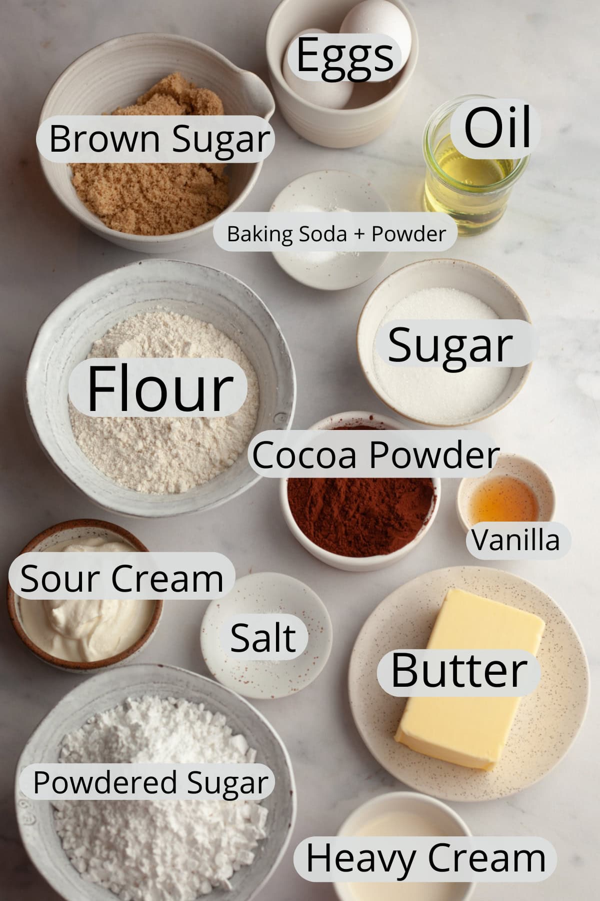 All the ingredients needed to make chocolate cupcakes with chocolate frosting, weighed out into small bowls.