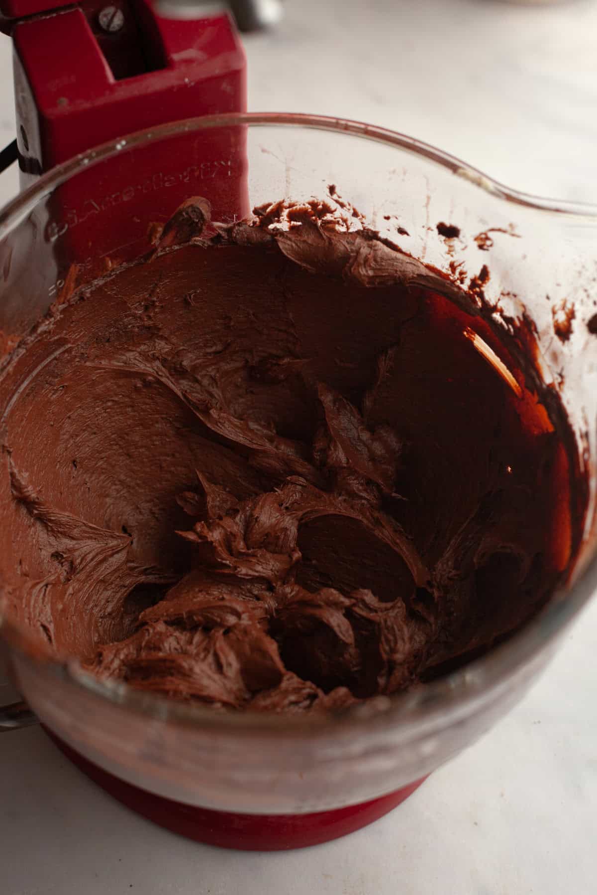 Chocolate frosting in a stand mixer.