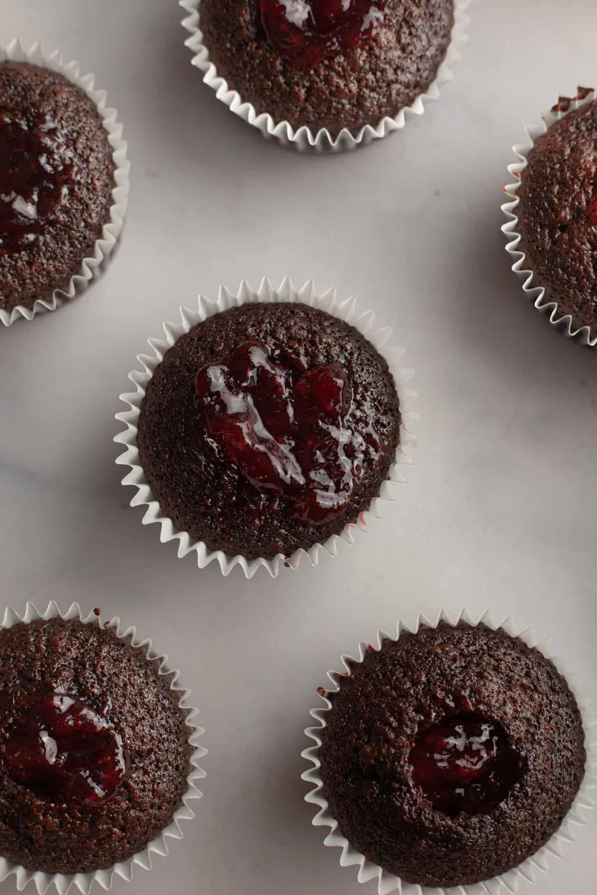 Chocolate cupcakes filled with strawberry jam.