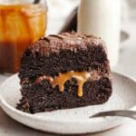 A slice of salted caramel chocolate cake on a small plate.