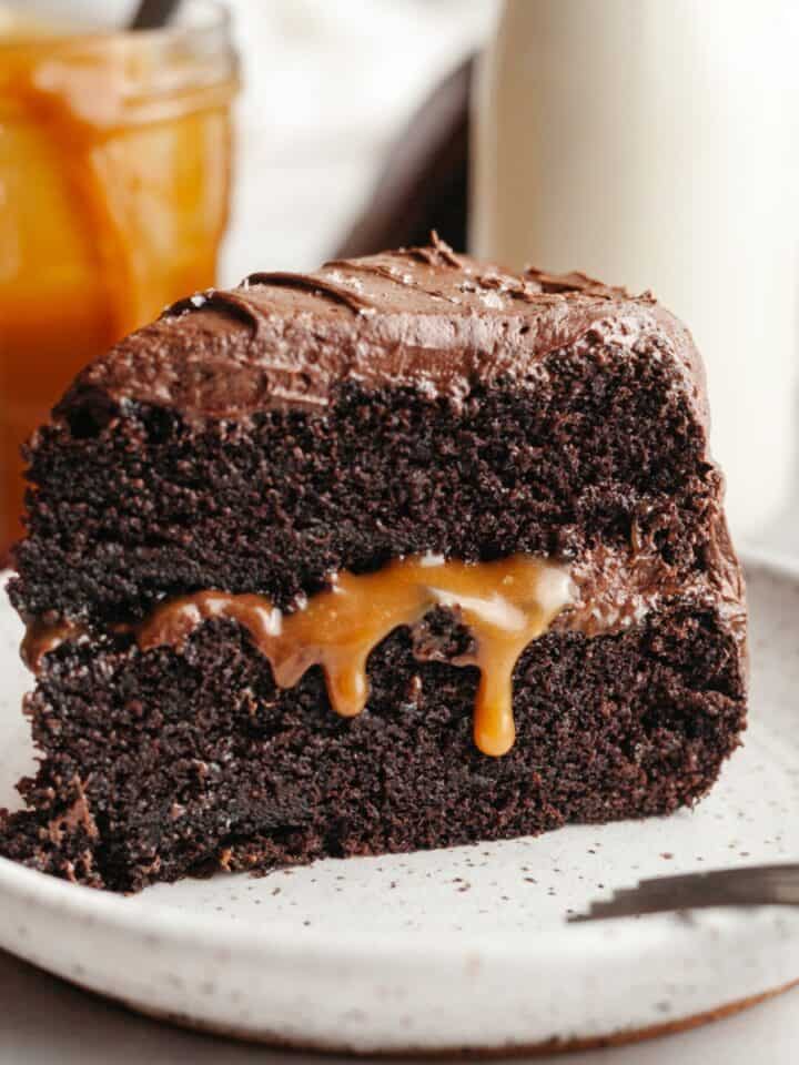 A slice of salted caramel chocolate cake on a small plate.