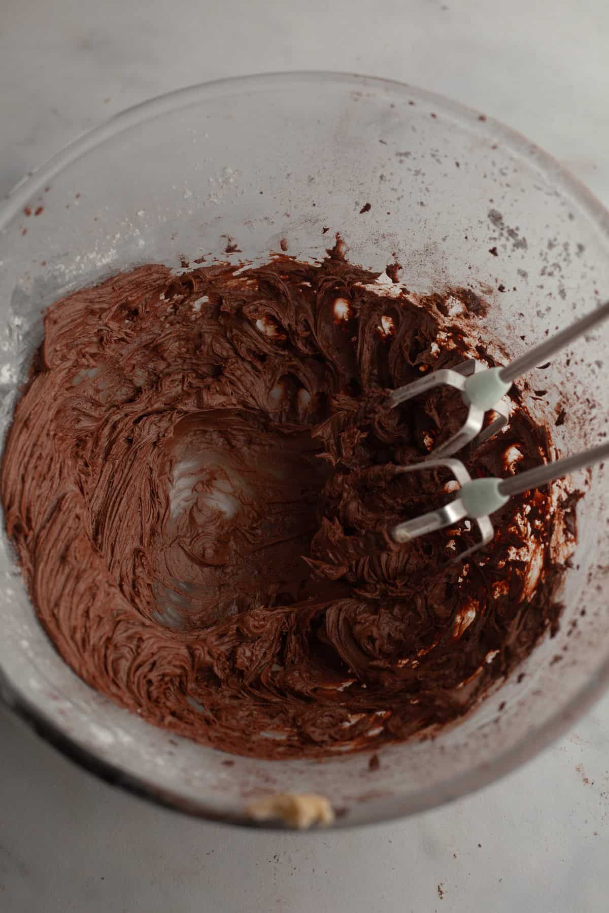 Chocolate sour cream frosting in a glass bowl.