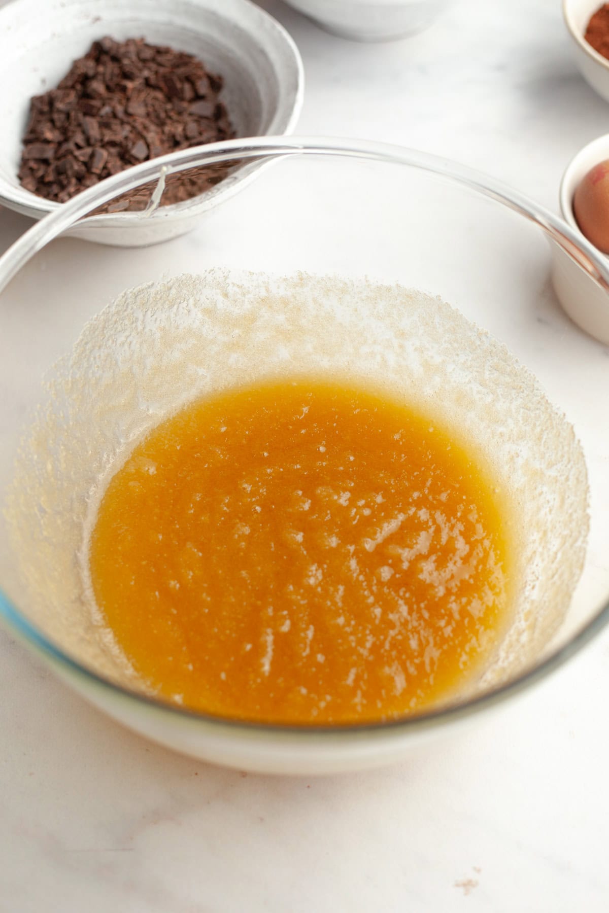 A large glass bowl with a yellow mixture in it.