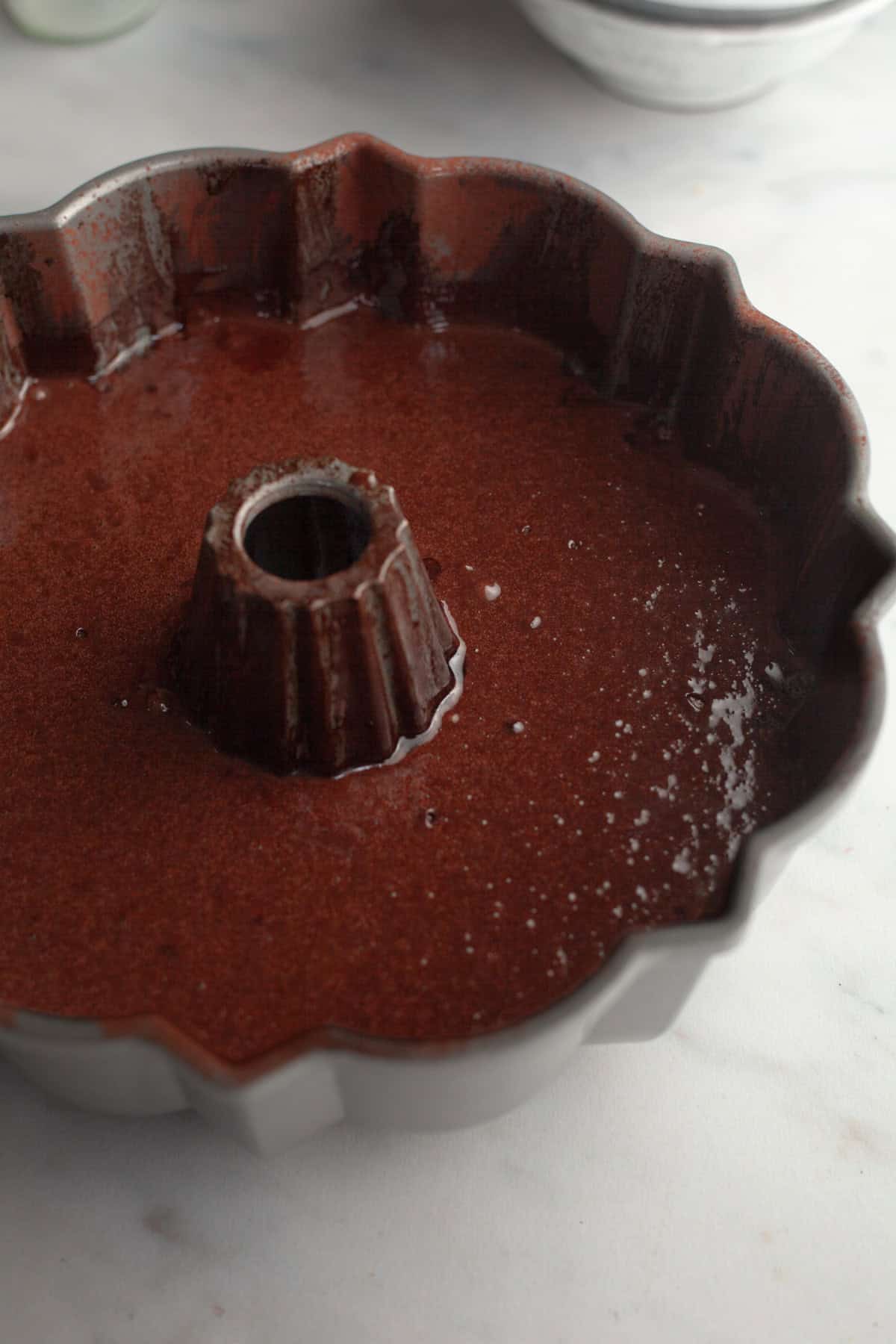A bundt pan with unbaked chocolate cake batter.
