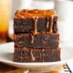 A stack of three brownies with salted caramel dripping down.