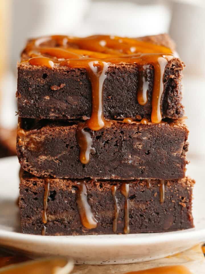 A stack of three brownies with salted caramel dripping down.