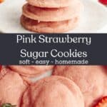 A close up of pink strawberry sugar cookies on parchment paper, there are a few sliced strawberries and a stack of cookies on a plate.