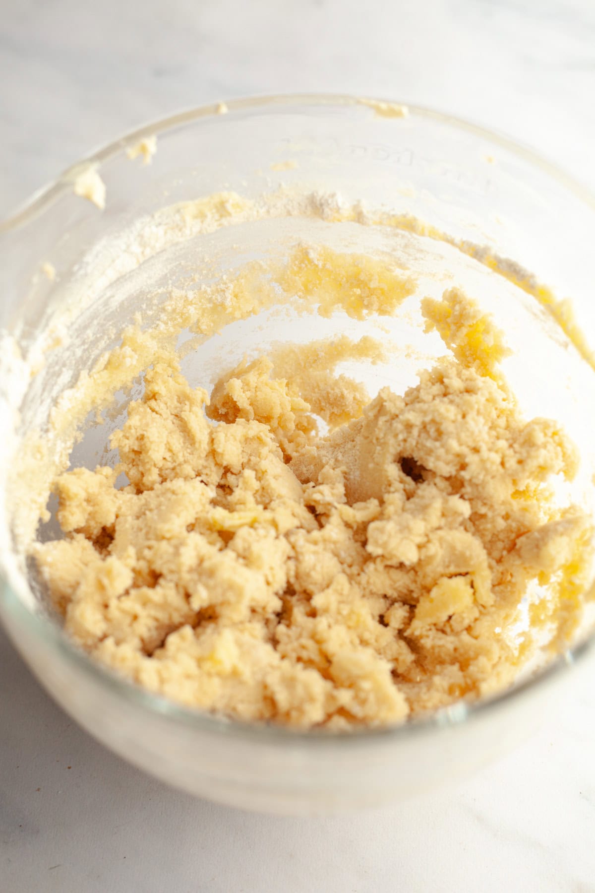 Sugar cookie dough in a glass mixing bowl.
