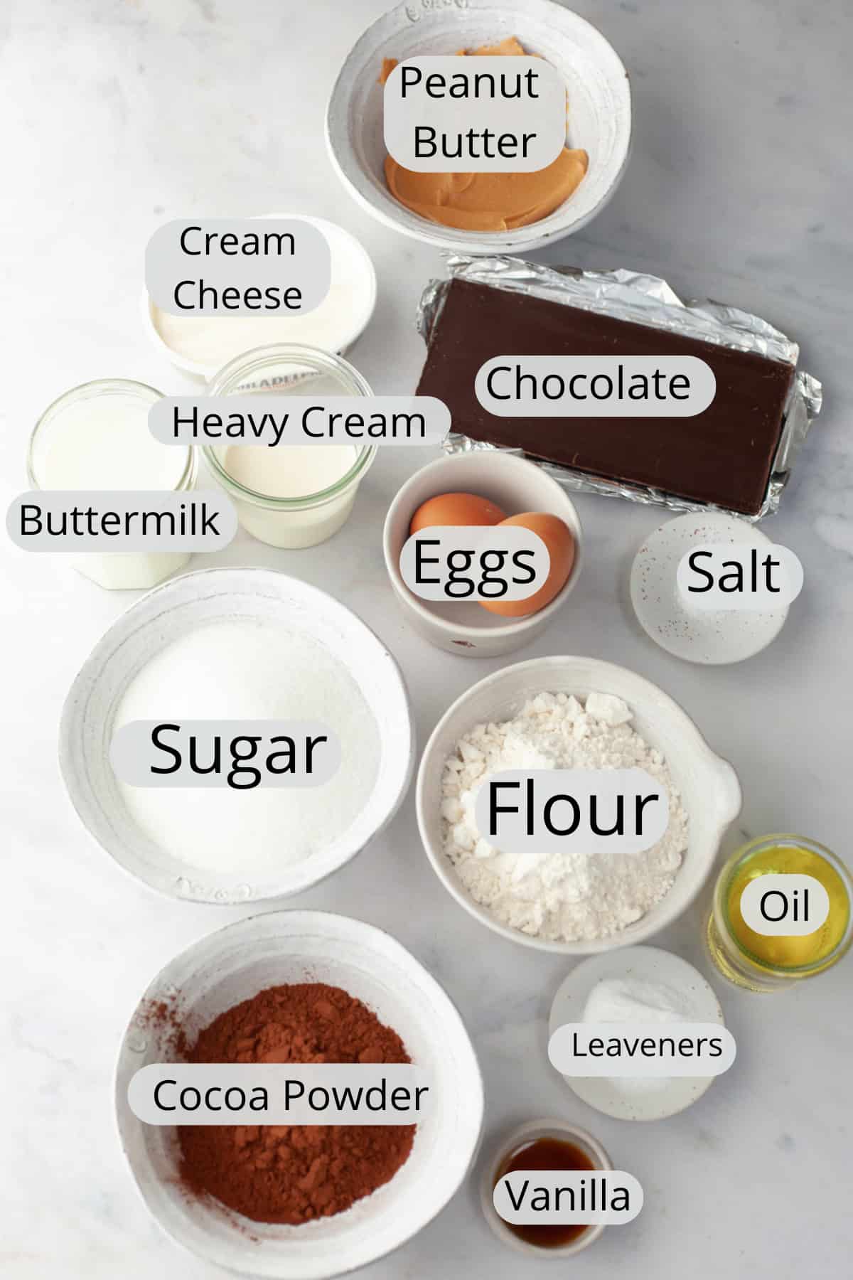 All the ingredients needed to make a peanut butter chocolate cake, weighed out into small bowls.