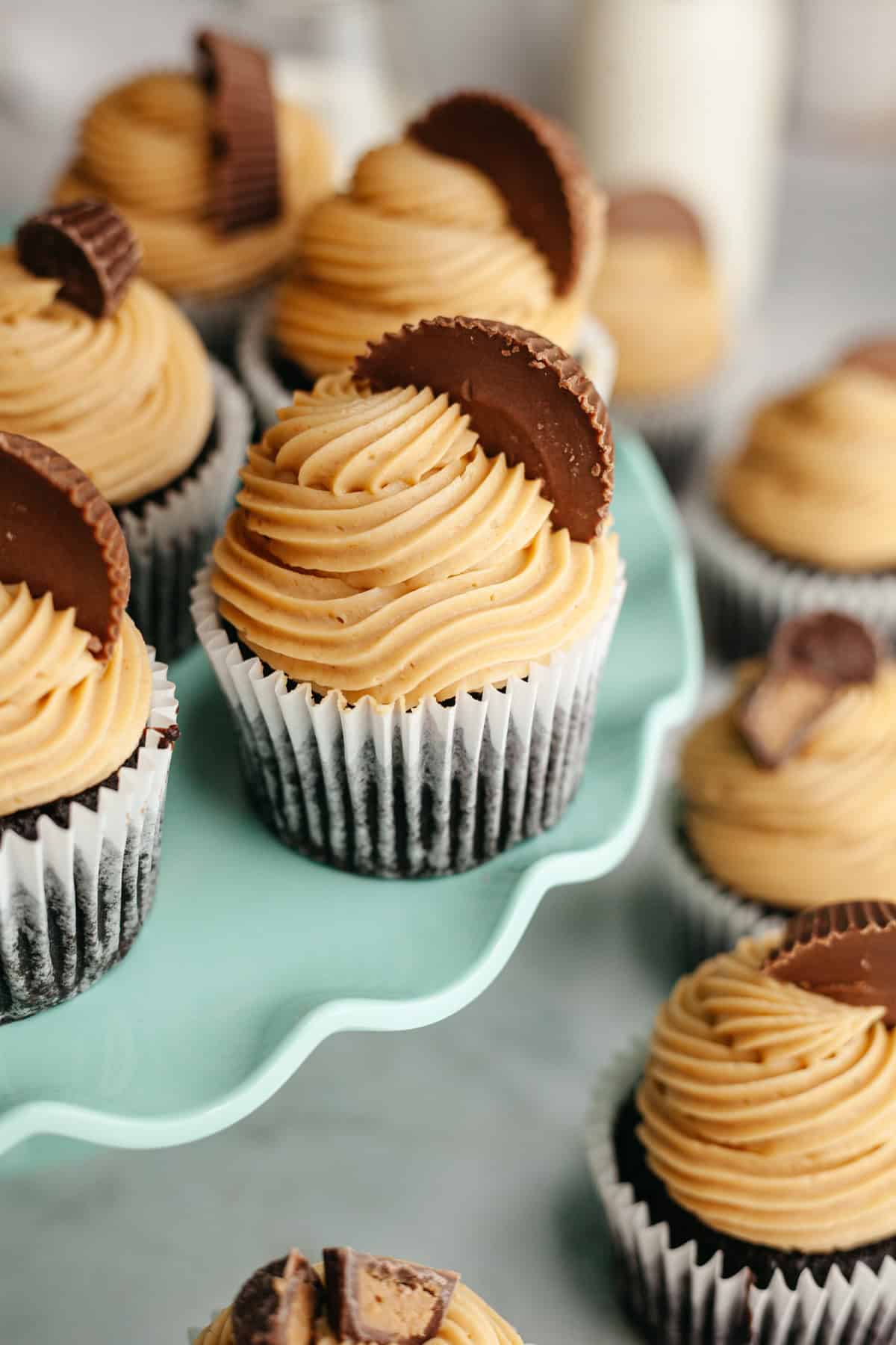 Chocolate cupcakes frosted with peanut butter frosting and topped with Reese's peanut butter cups.