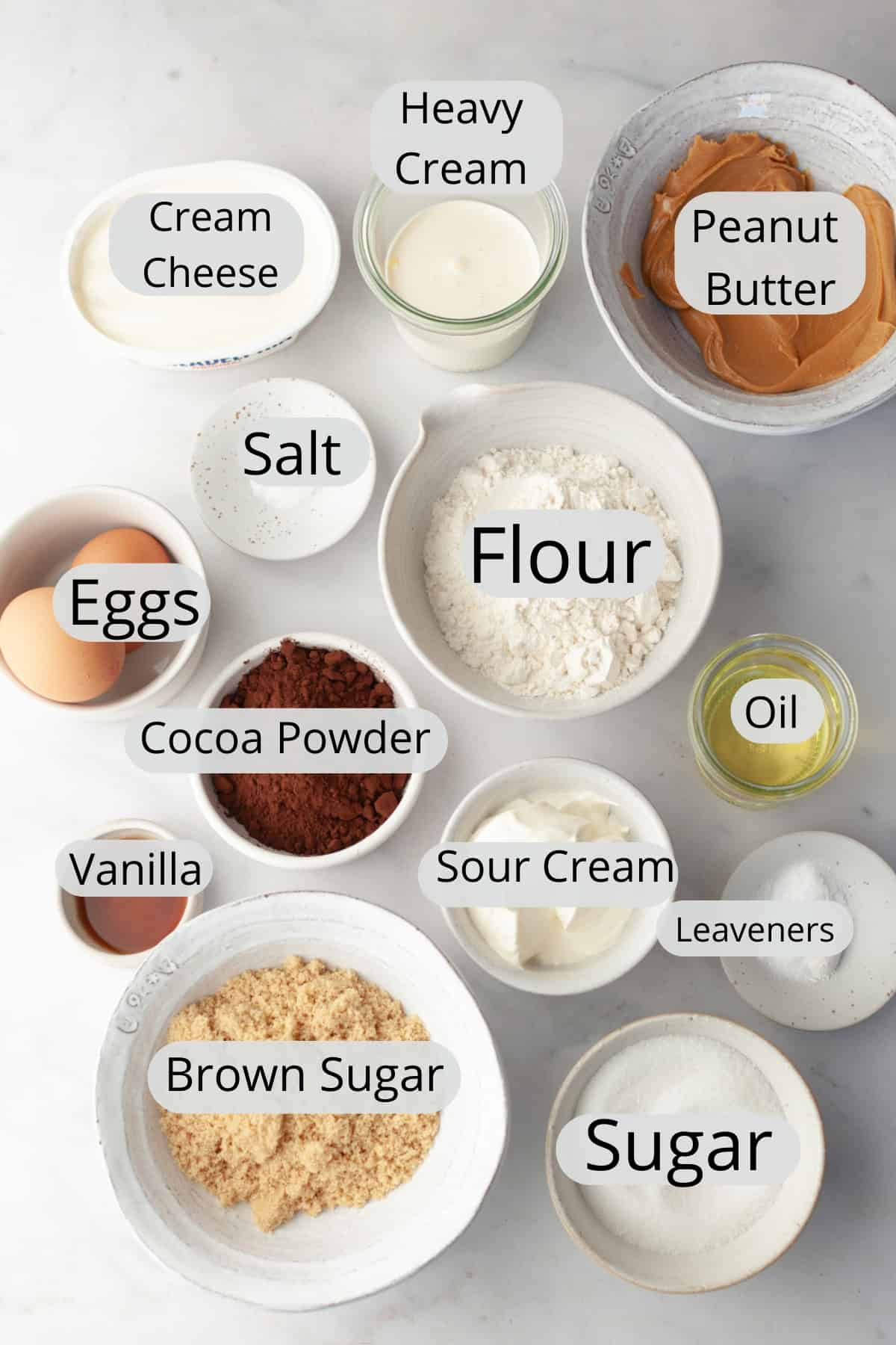 All the ingredients needed to make chocolate peanut butter cup cupcakes, weighed out into small bowls.