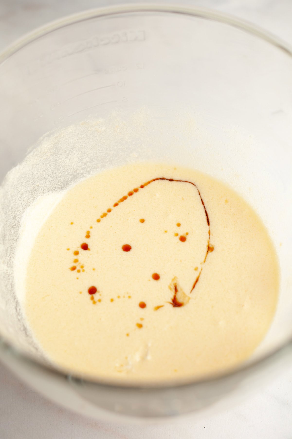 Vanilla cake batter with vanilla extract in a mixing bowl.