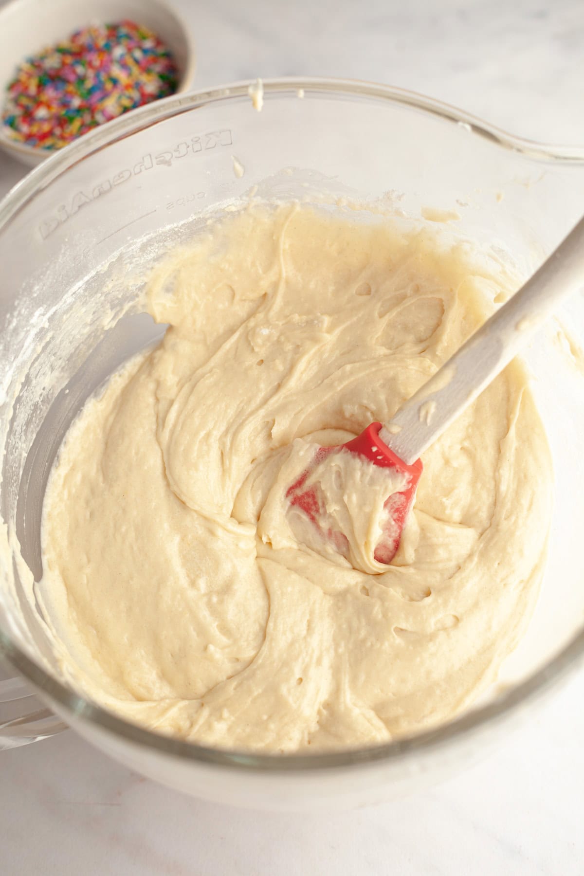 Vanilla cake batter in a glass mixing bowl.