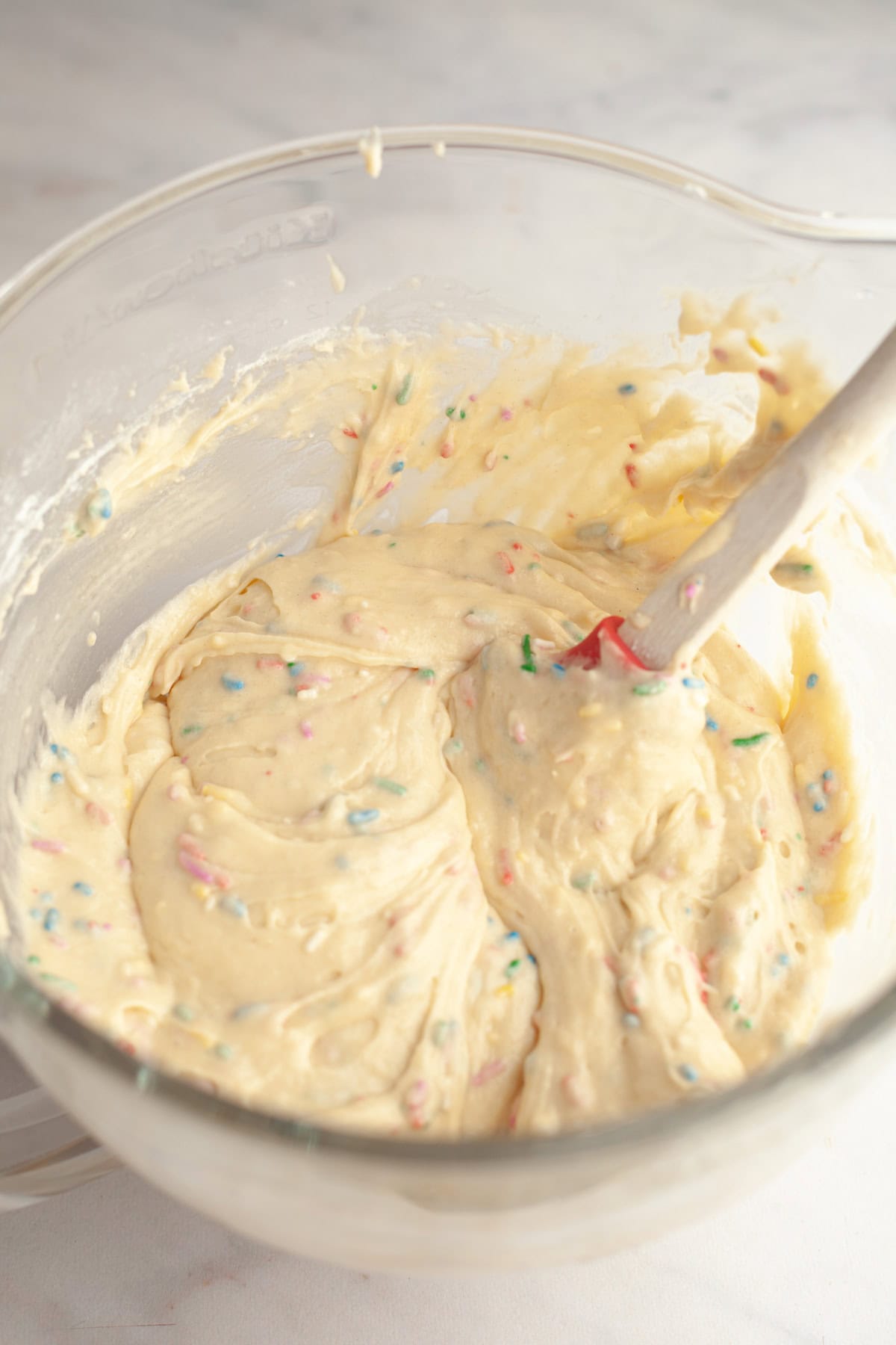 Funfetti cake batter in a glass mixing bowl.